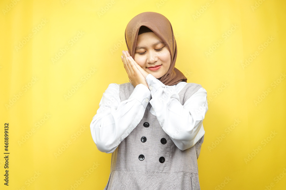 Beautiful asian young muslim woman sleeping peacefully, feeling comfortable, feeling happy, isolated on yellow background Beautiful asian young muslim woman sleeping peacefully, feeling comfortable, feeling happy, isolated on yellow background