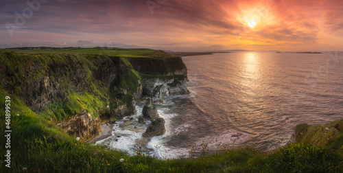 Wide panorama with beautiful white, limestone cliffs at dramatic sunset, seen from Magheracross viewpoint, Bushmills, Northern Ireland photo