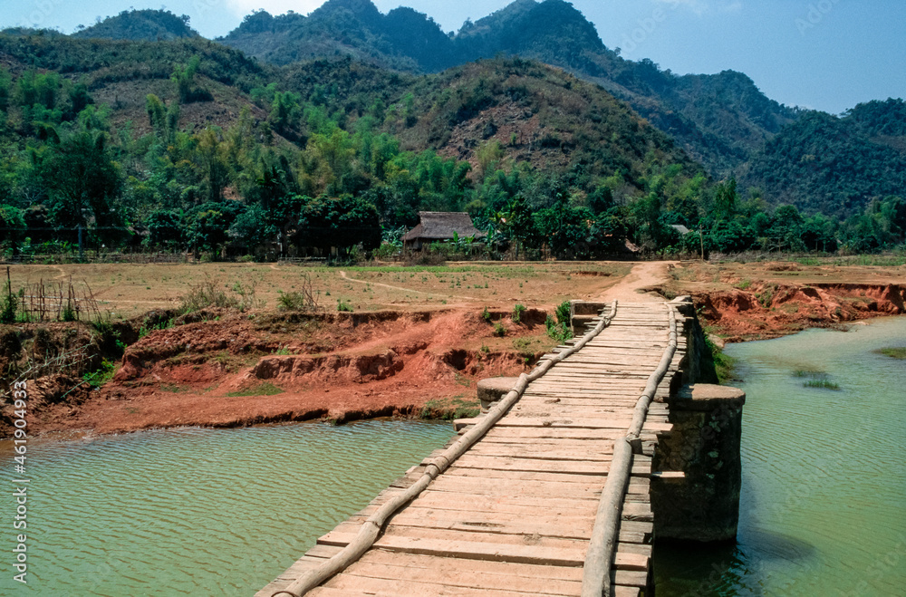 Eingescanntes Diapositiv einer historischen Farbaufnahme eines Holzstegs über einen Fluß in Vietnam