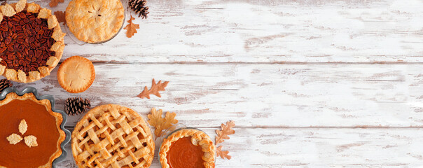 Selection of homemade autumn pies. Pumpkin, apple and pecan. Above view corner border on a white wood background with copy space.
