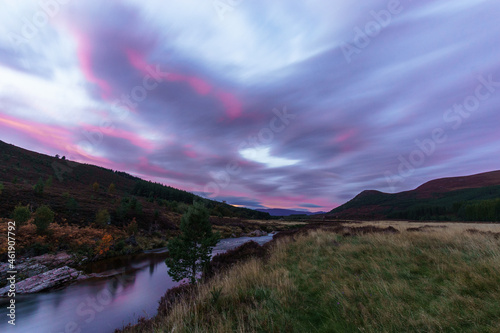 Glen Feshie with river with red illuminated clouds in evening time in Cairngorms National Park, Scotland