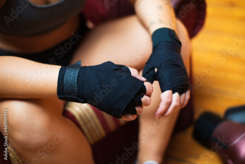 Close-up of wrist wrap. Black hand wrap on womans hands. Sport, healthy lifestyle, boxing concept
