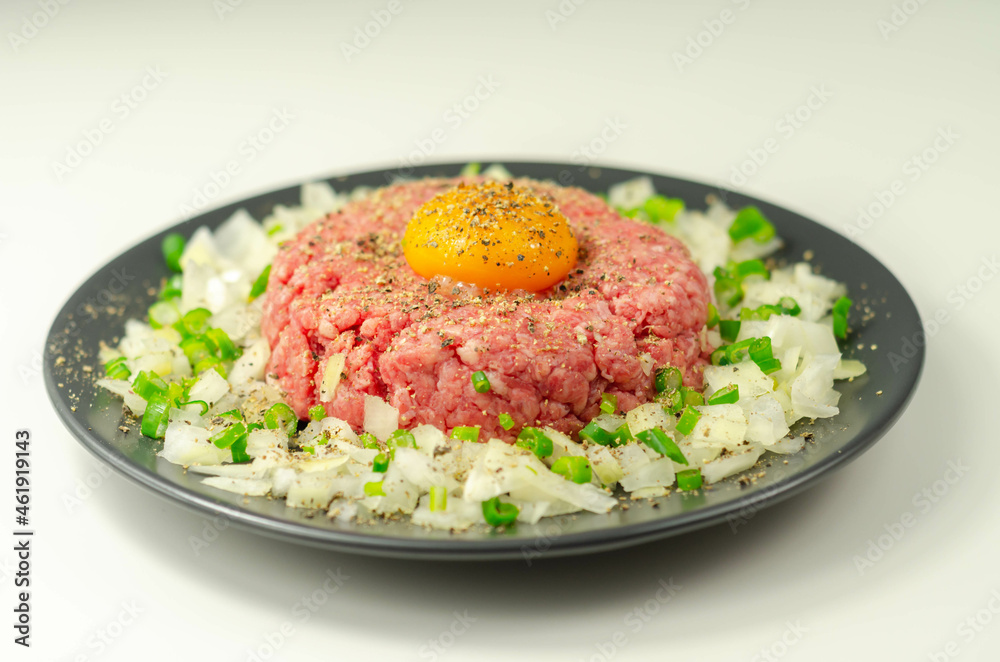 Beef steak tartare with raw egg yolk and onion with chive