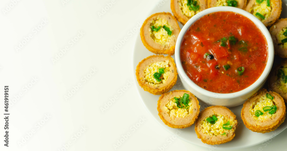 Mini scotch eggs with tomato sauce served on the white ceramic plate Mini scotch eggs with tomato sauce served on the white ceramic plate