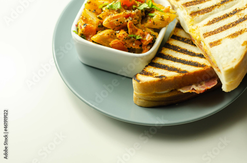 White bread with beechwood smoked bacon, egg, mayonnaise, and tomato served with Caesar pasta with parmesan cheese photo