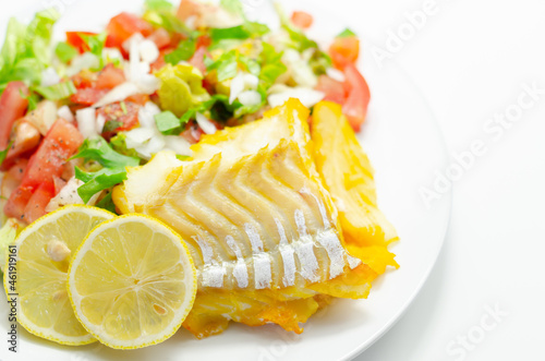 Smoked haddock fillet served with a fresh salad consisting of lettuce, tomatoes and onion