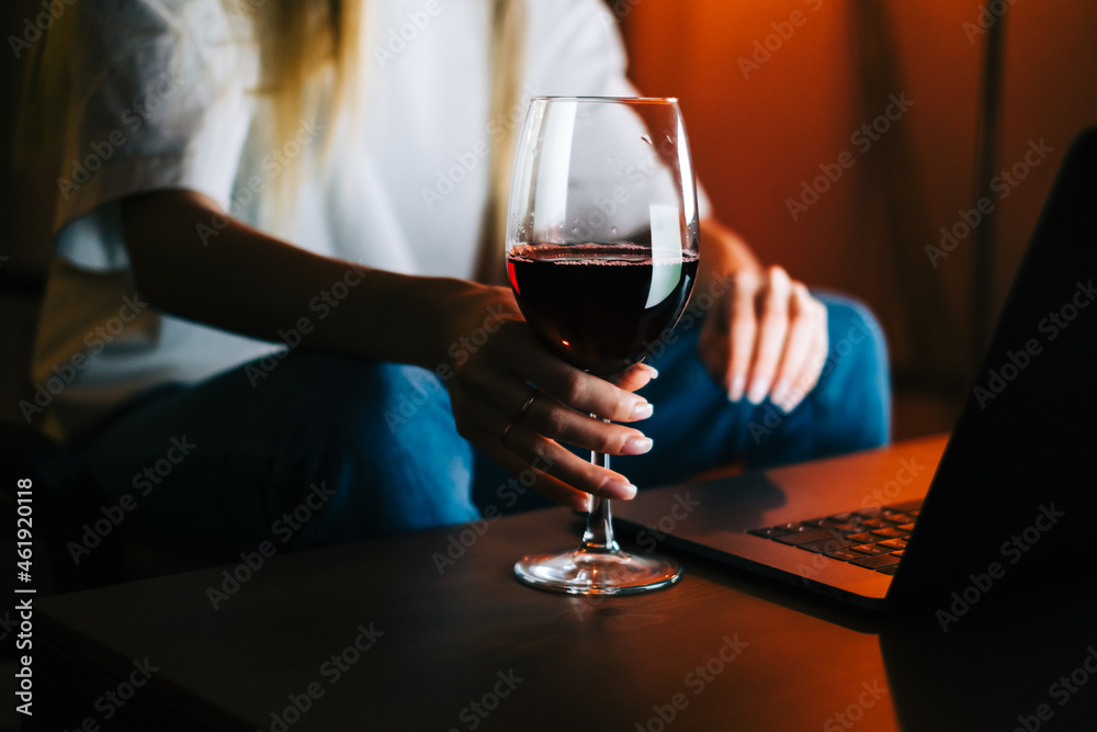 Young millennial woman having video call on laptop computer and drinking wine, use technology for communicate with friends or family. Young millennial woman having video call on laptop computer and drinking wine, use technology for communicate with friends or family.