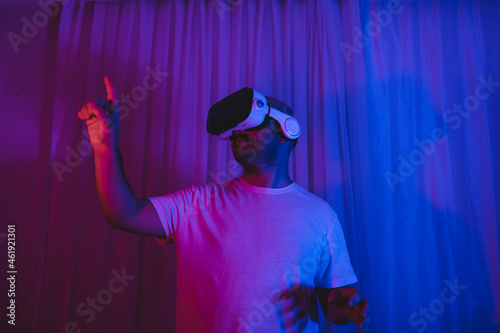 man wearing virtual glasses. in a room with blue and red lights. metaverse new concept new world.
