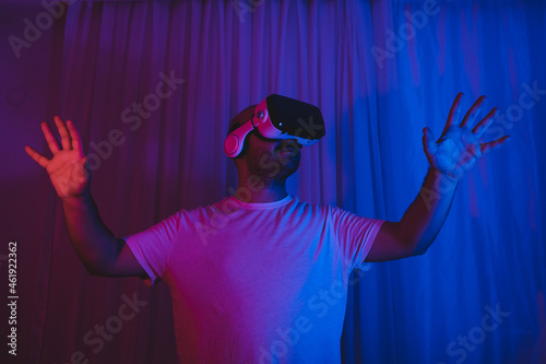 Young man entering the virtual world with bitcoin. man in vr glasses is holding btc coin in his hand. new technology blockchain.