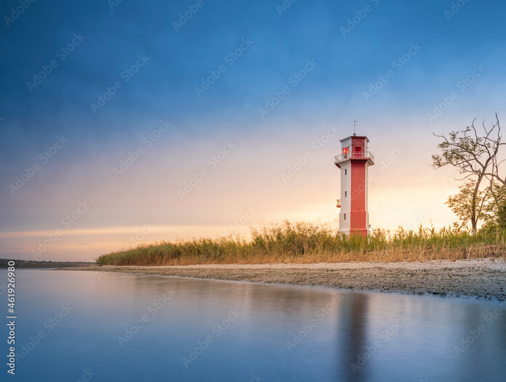 smooth silk water and view to old lighthouse under blue sky with copy space