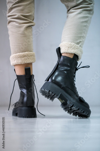 Crop of trendy autumn woman s fashion outfit: purple velour quilted bag, blue midi skirt, black chunky ankle boots. Copy, empty space for text