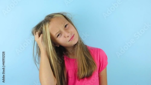 Girl scratches her head on a colored background