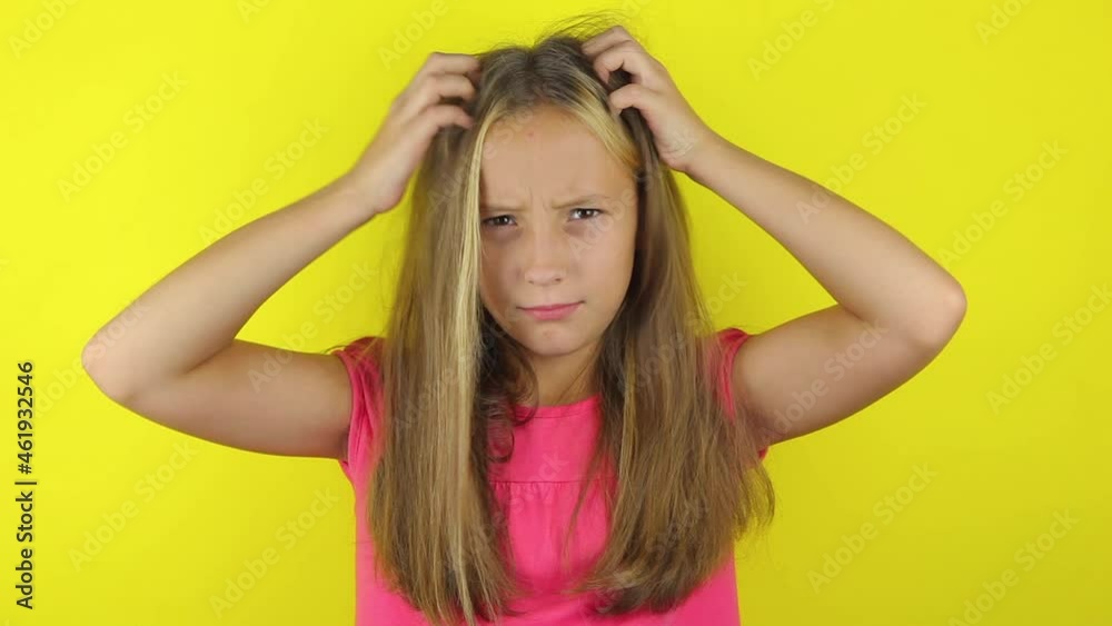 Girl scratches her head on a colored background Girl scratches her head on a colored background