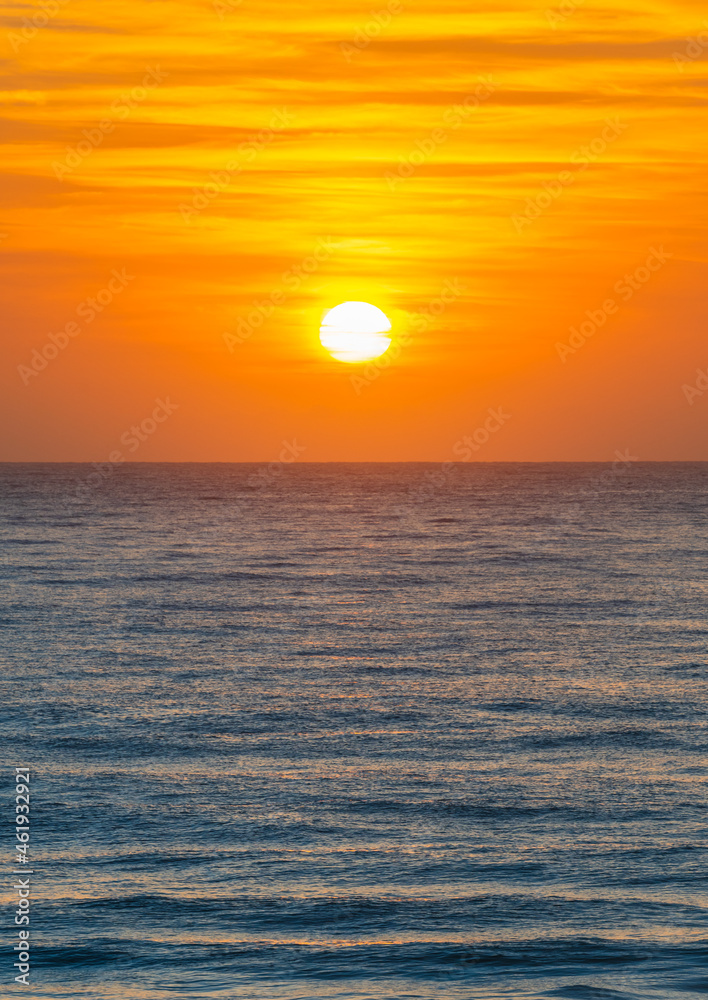 Orange sunrise with the sun over the sea