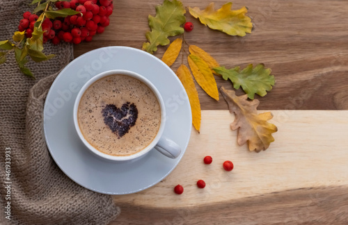 A cup of coffee, with a heart of chocolate on a beautiful autumn phonon. Layout with space for text. photo