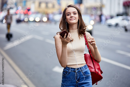 Slim woman is calling by smartphone near traffic. © grigvovan