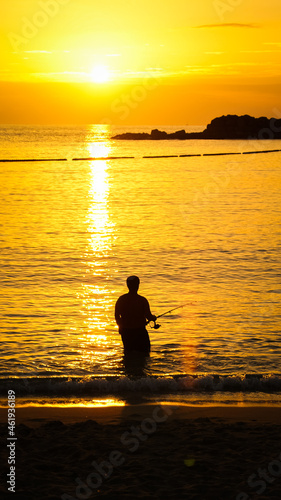 man fishing during sunset ocean summer