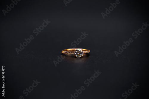 gold ring with diamond on black background