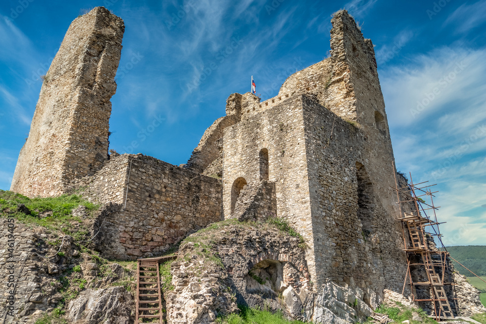 Aerial view of medieval ruined Gothic Divín castle in Southern Slovakia near Lucenec under restoration with cloudy sky background 