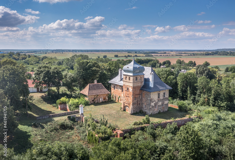 Aerial view of medieval fortified castle Erdody manor house in Janoshaza, Vas county Hungary with restored onion shape roof and blue sky, surrounded by a dry moat
