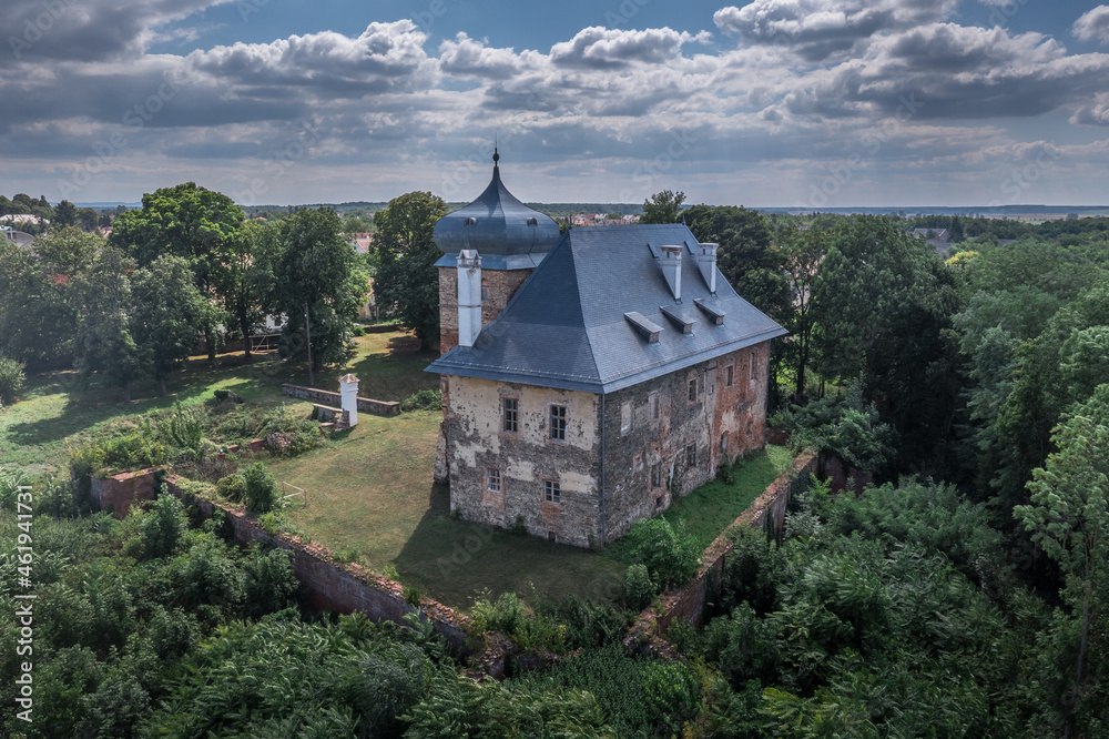 Aerial view of medieval fortified castle Erdody manor house in Janoshaza, Vas county Hungary with restored onion shape roof and blue sky, surrounded by a dry moat