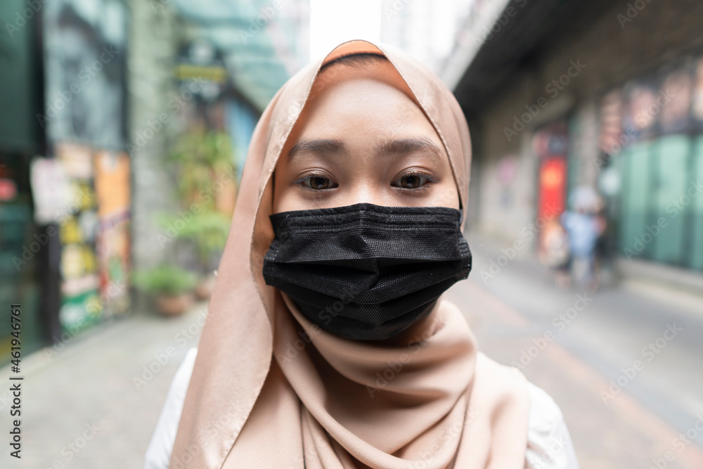 Fully vaccinated malay lady having a good time smile thru the face mask - close up Fully vaccinated malay lady having a good time smile thru the face mask - close up