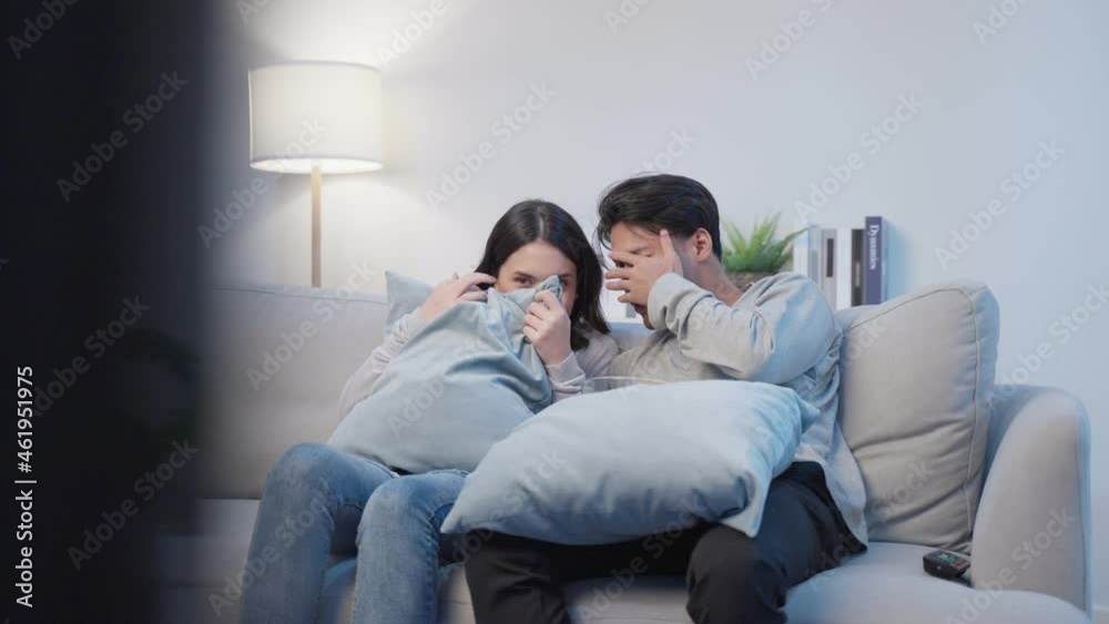 Asian young loving couple watch movie together in living room at home. Asian young loving couple watch movie together in living room at home.