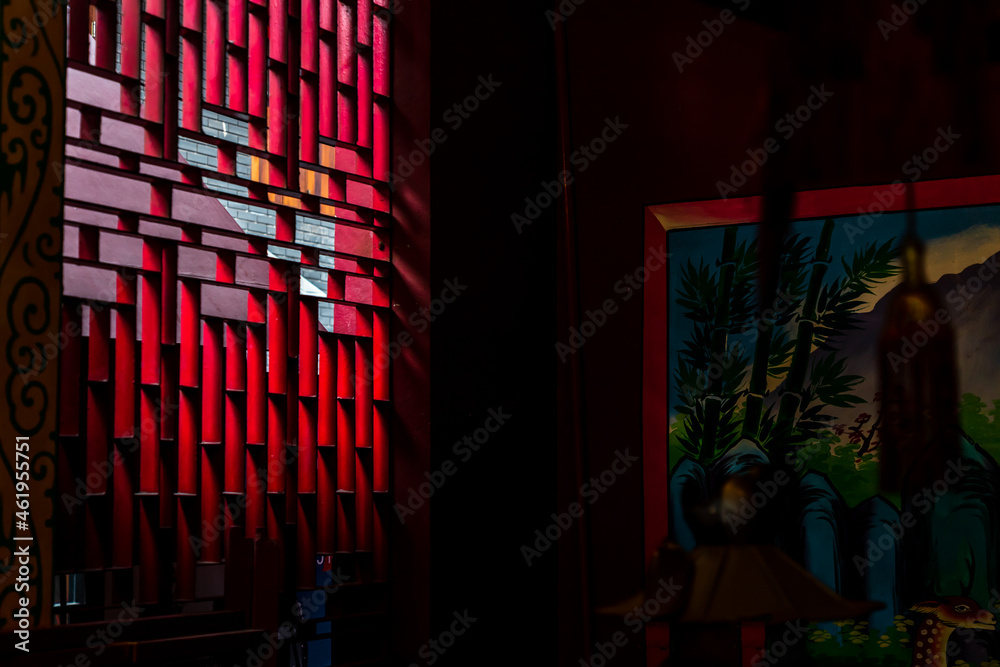 Bangkok, Thailand - Aug 01, 2020 : Light shines through the vent shade in the Chinese shrine\'s. Selective focus.