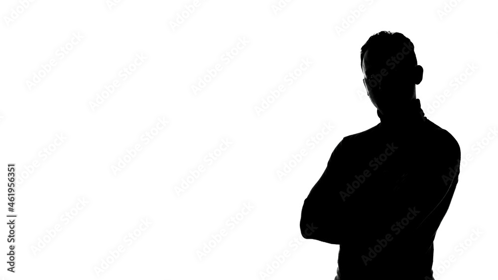 Photo of man's silhouette with arms crossed and copyspace Photo of man's silhouette with arms crossed and copyspace