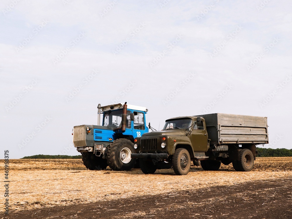 Truck and tractor stand in the field. Truck and tractor stand in the field.