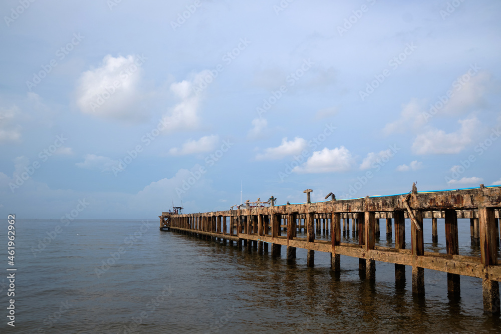 Old boat pier at sea beach with blue sky and clouds background