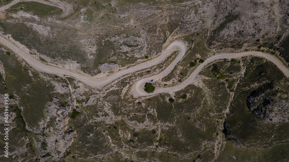 Obraz premium Vehicle Moving along Serpantine Road in Highlands. Aerial View