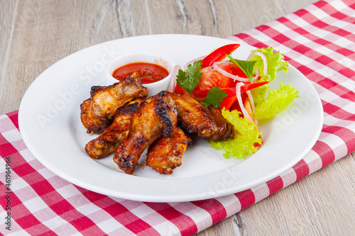 BBQ chicken wings with red sauce and vegetables