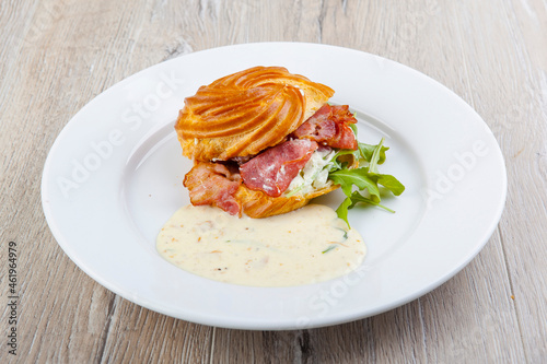 pap with egg benedict bacon cheese sauce on a white plate