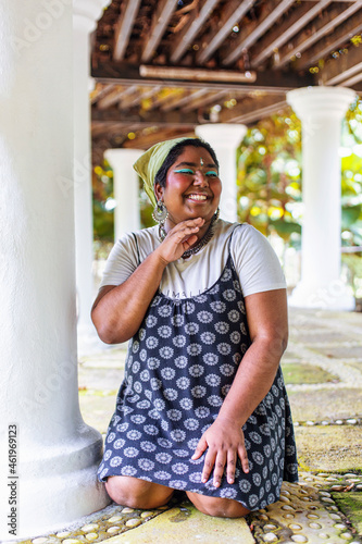 dark skinned Indian non-binary individual smiling in park photo