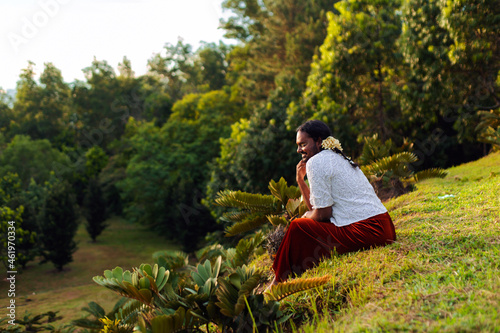 portrait of dark skinned Indian non-binary individual with traditional female attire in park