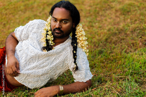 portrait of dark skinned Indian non-binary individual with traditional female attire in park