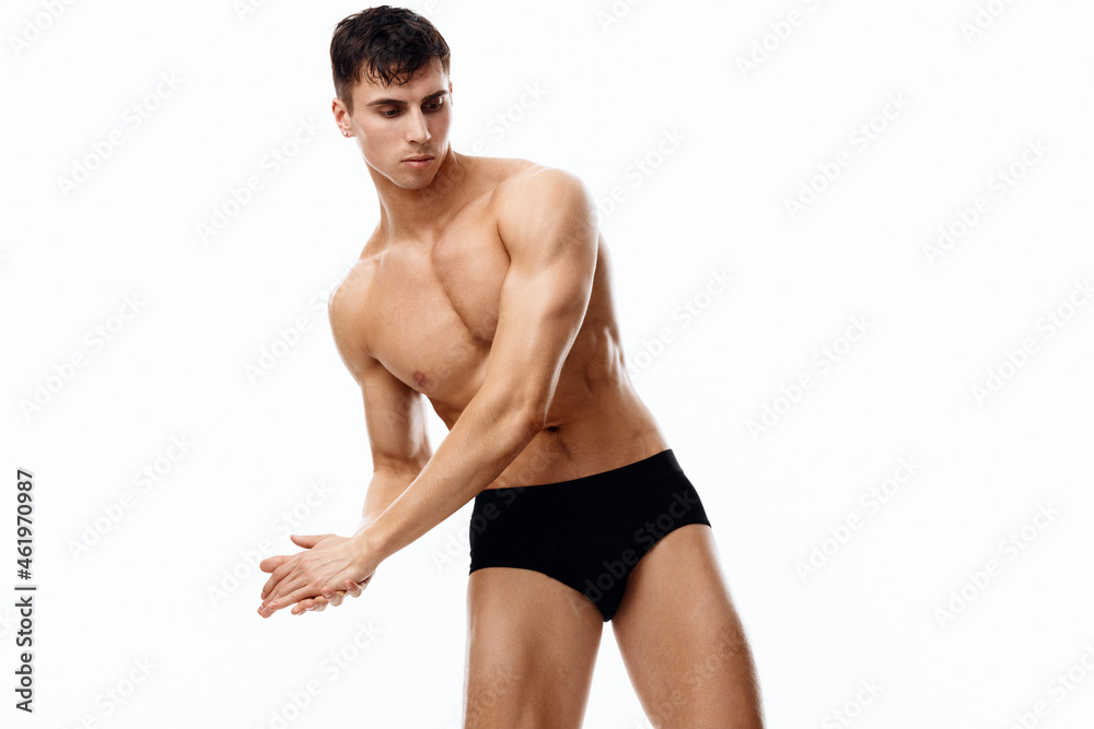 a man joined his hands and bent over to the side on a light background naked torso black panties model a man joined his hands and bent over to the side on a light background naked torso black panties model
