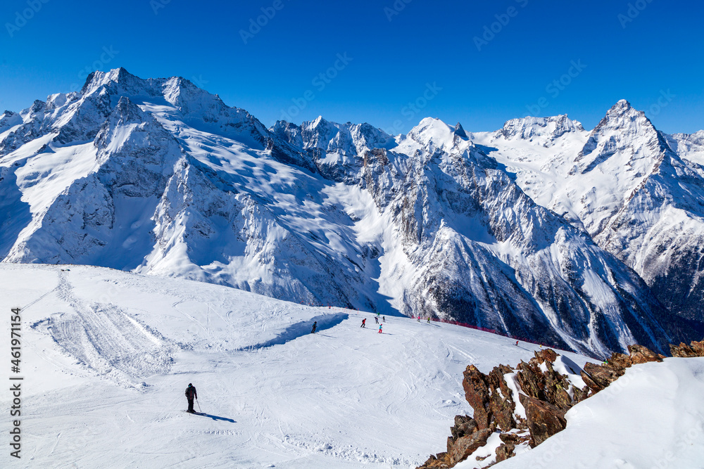 Caucasus Mountains, Panoramic view of the ski slope  on the horizon in winter day. Dombai ski resort, Western Caucasus, Karachai-Cherkess, Russia.