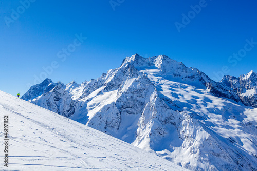 Caucasus Mountains, Panoramic view of the ski slope on the horizon in winter day. Dombai ski resort, Western Caucasus, Karachai-Cherkess, Russia.