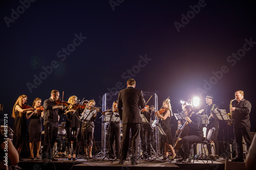 Obraz na plátně Orchestra performing live concert under blue night sky