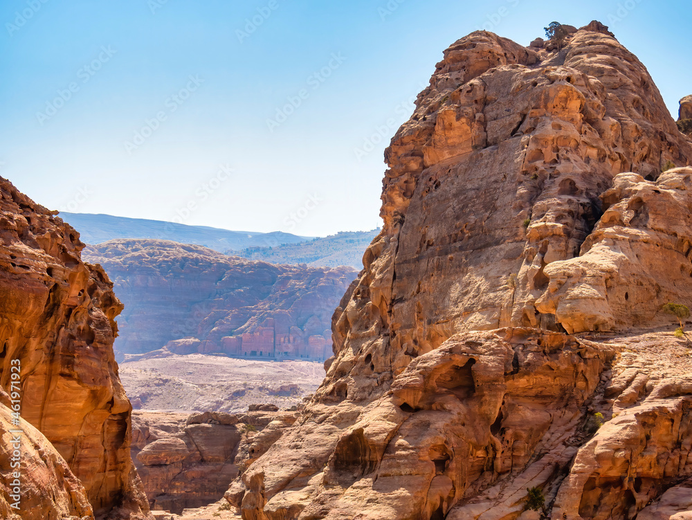 Rocky desert landscape from the ancient city of Petra, Jordan with the Royal Tombs in the background.