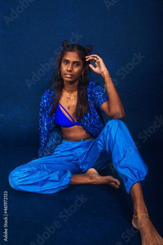 Photography portrait of dark skinned Indian woman from Malaysia against dark blue background