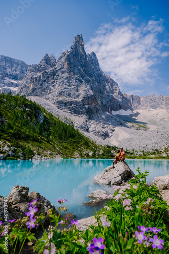 Lake Sorapis Italian Dolomites, Morning with clear sky on Lago di Sorapis in Italian Dolomites, lake with unique turquoise color water in Belluno province in Nothern Italy. couple in the mountains photo