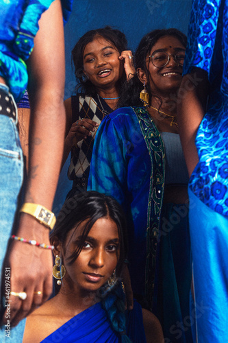 group portraits of dark skinned Indian women from Malaysia against a dark blue background photo