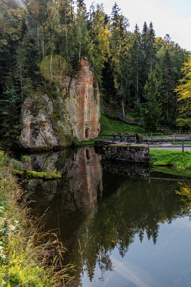 Autumn Foliage Reflected in a River in a Forest with Caves