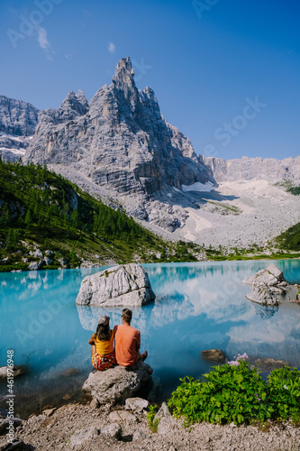 Lake Sorapis Italian Dolomites, Morning with clear sky on Lago di Sorapis in Italian Dolomites, lake with unique turquoise color water in Belluno province in Nothern Italy. couple in the mountains photo