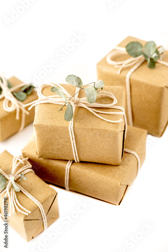 Christmas rustic present gift boxes isolated on a white background. Craft paper and eucalyptus leaves.