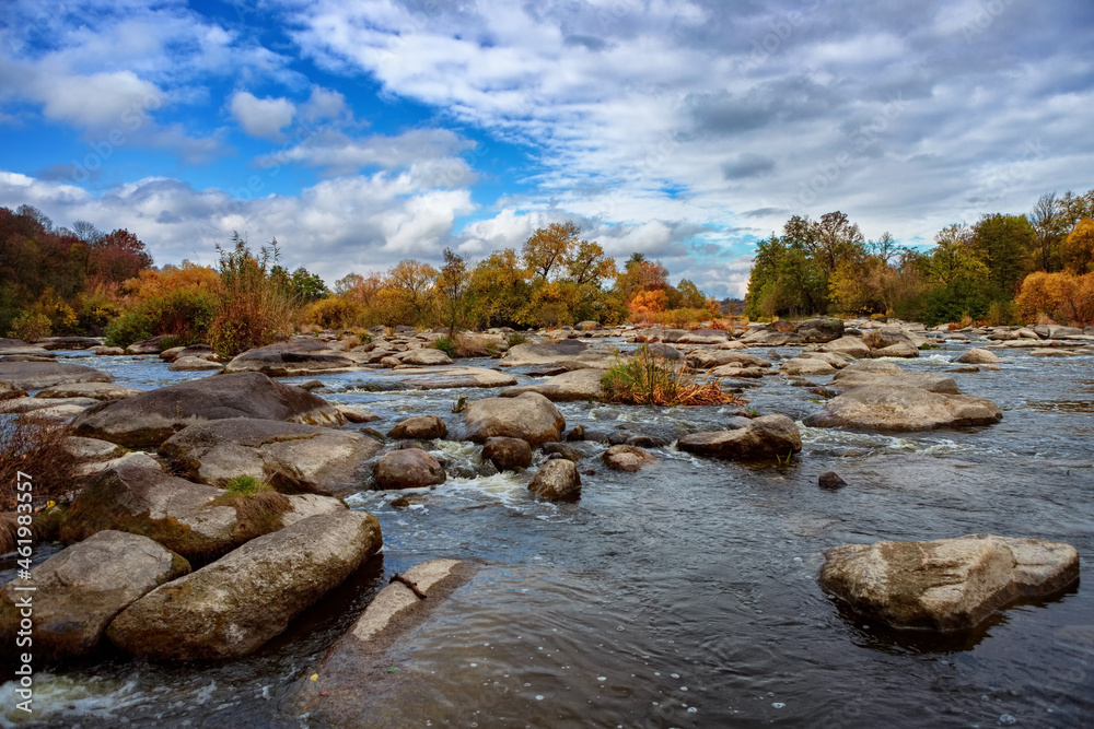 Autumn river with beautiful large stones, blue sky and trees Autumn river with beautiful large stones, blue sky and trees