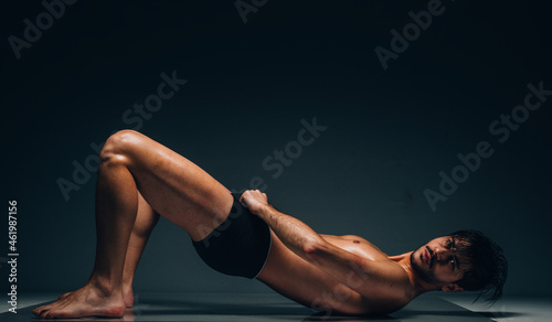 Handsome silhouette man in underwear on dark background